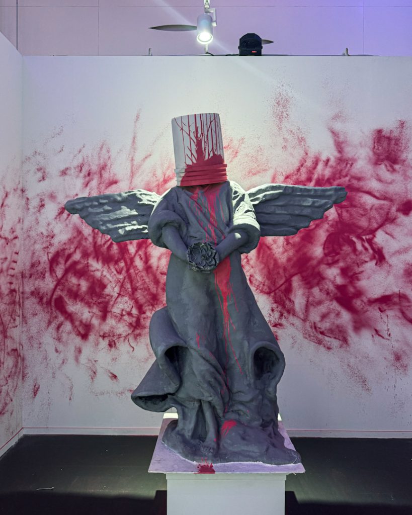 Statue with red bucket above its head