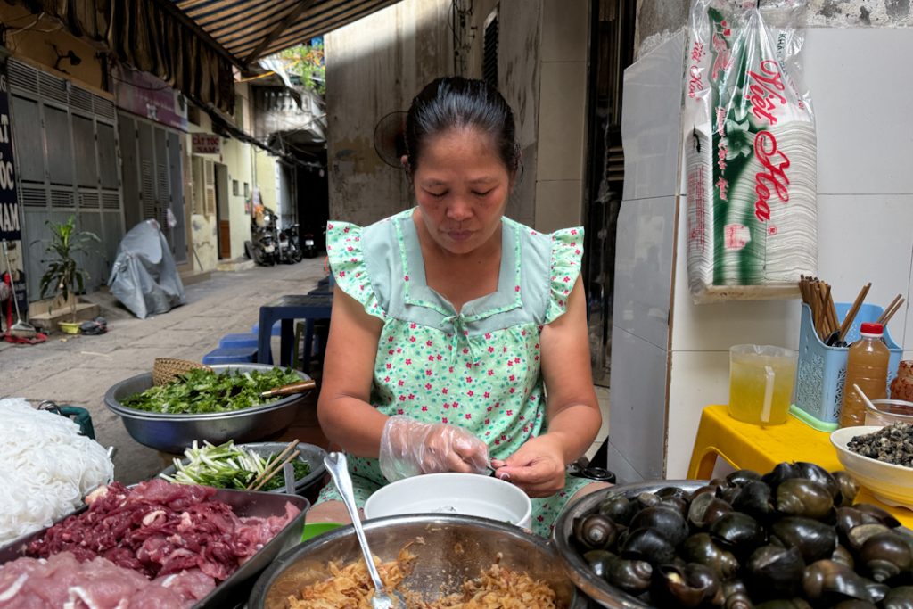 Vietnamese store owner cooking up a bowl of Crab Noodles