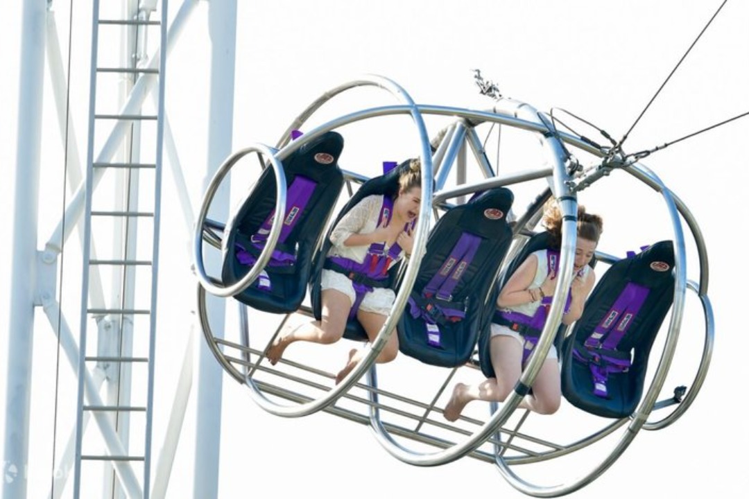 G-Max Reverse Bungy capsule lit up at night over Clarke Quay riverside
